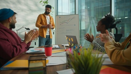 Business presentation in office team meeting briefing happy smiling Hindu leader presenting corporate data good growth result achieved successful multiethnic informal four businesspeople applauding