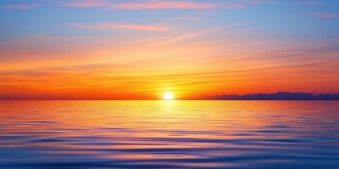 Obraz premium Ocean horizon at sunset vibrant orange and yellow sky reflects on gentle water ripples distant mountains silhouette