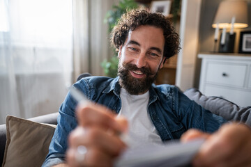 Naklejka premium Smiling man making online payment with credit card