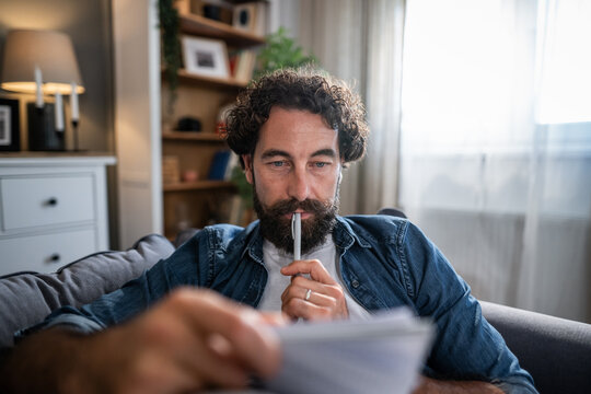 Man thinking about document while planning finances at home