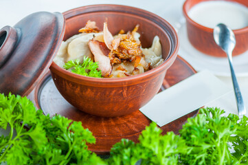 Boiled vereniki seasoned with fried onions in a clay pot