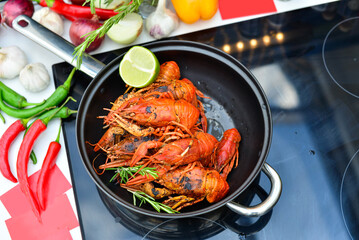 pot of boiled crayfish with lemons and herbs on the stove