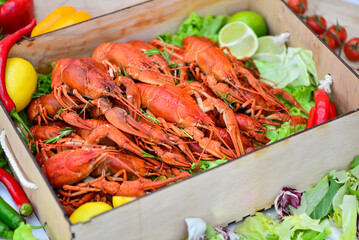 box of boiled crayfish with salad and lemons