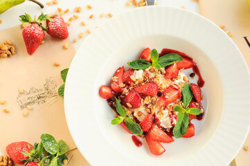 Pankota with fresh strawberries in a white plate on a table with food decor