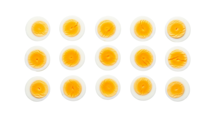 Halved hard boiled eggs display yellow yolks against their bases on a isolated background.
