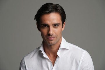 A Portrait of a Confident Young Man with an Engaging Smile, Captured in a Studio Setting Against a Neutral Gray Background