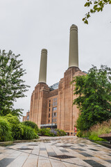 Battersea Power Station chimneys, London heritage landmark amid lush plants