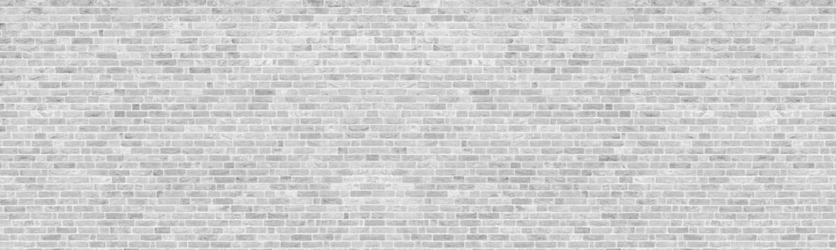 White washed shabby brick wall wide panoramic texture. Light gray rough whitewashed brickwork backdrop panorama. Abstract rustic vintage wallpaper background