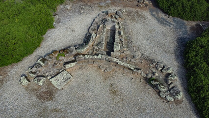 Drone view of a Sardinian prehistoric tomb with trilobed structure and stone remains in natural...