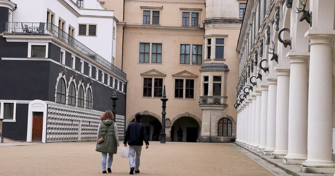 Dresden Germany city Stallhof building couple. Industrial center of East Germany, now unified German, European Union (EU) and NATO. Total destruction in WW II. Palace rebuilt historically.