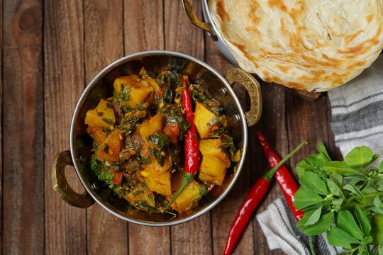Homemade Aloo methi - potatoes with fenugreek leaves masala served with paratha