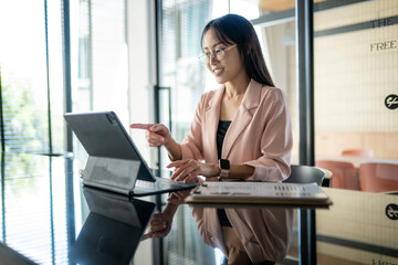 Businesswoman working with tablet and financial reports in modern office © Apichat