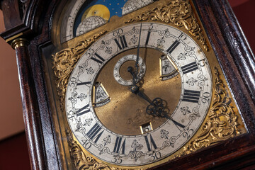 A detailed shot of a vintage grandfather clock featuring a brass center,