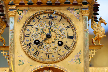 An ornate, gilded clock with Roman numerals and decorative patterns
