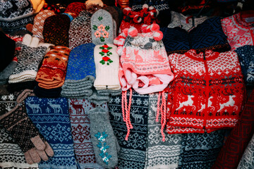 Traditional Christmas Winter Market Trading Houses With Warm Clothes, Wear And Hats. Colorful Knitted Traditional European Warm Clothes - Mittens and Scarfs. Xmas Souvenir From Europe.
