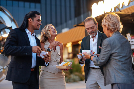 Business Friends Sharing Snacks and Conversation During Evening Outdoor Networking in Madrid City Lifestyle Event
