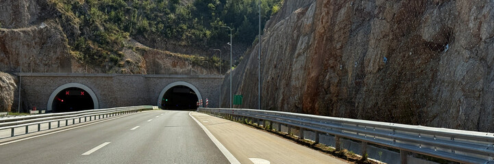 Sunlit asphalt yawns toward twin stone tunnels, echoing whispers of road trip daydreams and Solstice wanderlust through limestone echoes