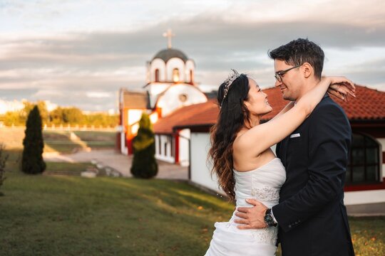 Interracial wedding couple embracing after ceremony at church