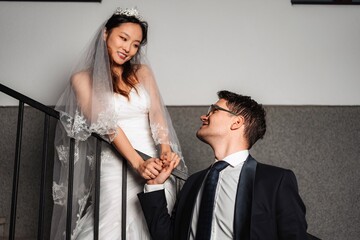Interracial couple celebrating wedding holding hands on stairs