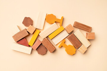 Wooden children's construction set blocks of different shapes natural colors on beige background. Montessori style cubes game for toddlers flat lay top view. Concept of learning and education