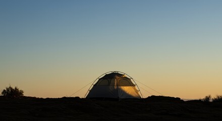 Adventure tent silhouetted against a dramatic desert sunrise or sunset sky with ample copy space