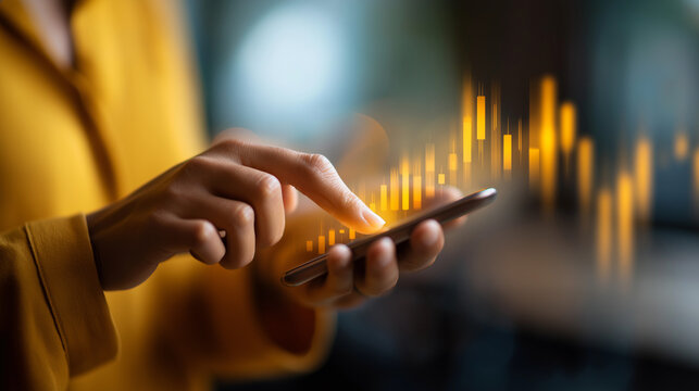 crop of a businesswoman’s hand swiping on a fintech app candlestick shapes recognizable but generic stone wall defocused gentle side light space on right faceless
