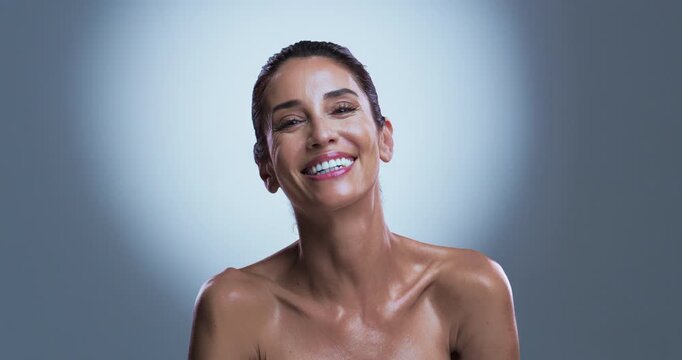 Face, beauty and woman in studio with smile for wellness, skincare or anti aging transformation. Mature, happy or female person with spotlight for smooth skin, dermatology or pride on gray background