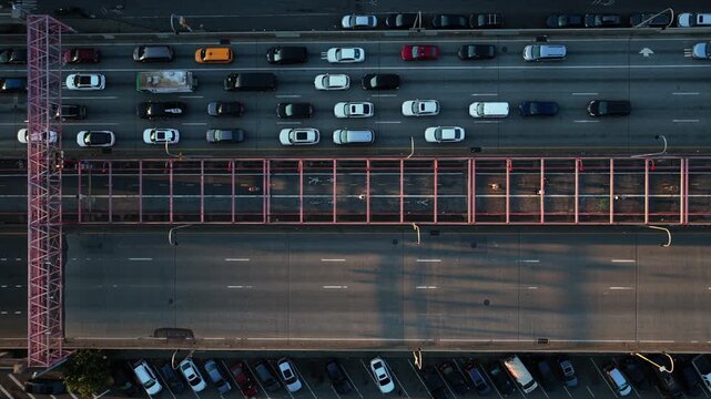 Overhead aerial view of the Williamsburg Bridge in New York City, capturing the bustling traffic and iconic shadow patterns during late afternoon