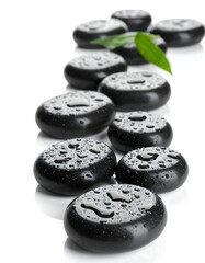 Black stones arranged with water droplets and a green leaf