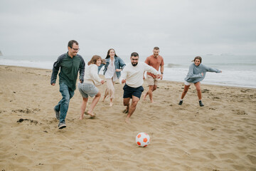 A group of people playing soccer on a beach. Scene is fun and lighthearted © Reuben