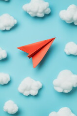 A red paper airplane on a blue background with white clouds