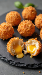 Crispy golden balls filled with creamy yolk, perfect for savory snack or appetizer. These delicious treats are sure to delight any palate