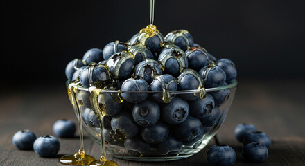 Fresh blueberries in glass bowl drizzled with golden honey, a healthy and delicious breakfast or snack for wellbeing and mindful eating