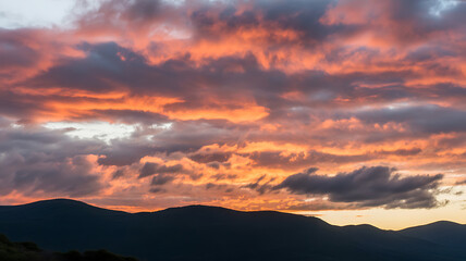 Dramatic Sunset Sky with Fiery Clouds Over Mountain Range, Nature Landscape at Dusk, Colorful Cloudscape, Atmospheric View