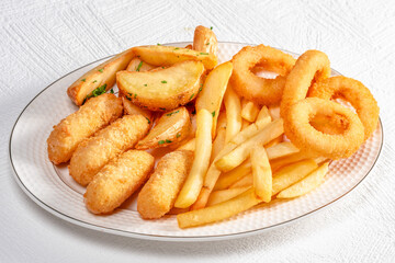 Crispy fried snacks served on a plate with onion rings, fries, and potato wedges for a tasty meal