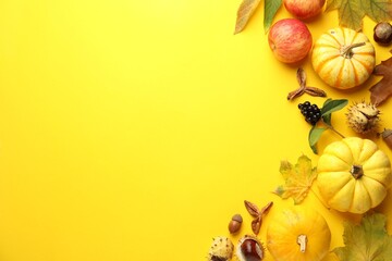 Flat lay composition with dry autumn leaves and pumpkins on yellow background. Space for text