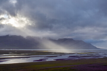 Sunlight breaks through stormy clouds over water channels
