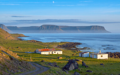 Remote coastal homes bathed in golden hour light