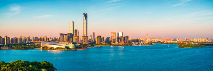 Beautiful modern city skyline with tall skyscrapers and waterfront architecture along the lake under a clear sky in Suzhou, China.