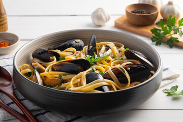 Green mussel fettuccine pasta with white wine and chilli garlic in a plate.