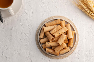 Khanom Thong Muan, crispy egg roll,Thai sweetmeat made of flour, coconut milk and egg in white bowl.Top view.