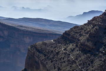 Layered mountains fade into a hazy blue distance