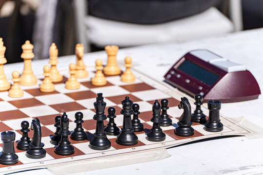 Close-up of a Chess board and timer on a table outdoors