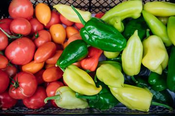 Ripe green pepper and red tomato, collected in a box. Autumn harvest.