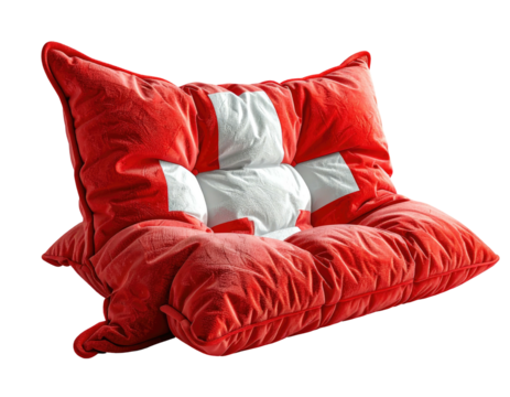 A plush, overstuffed pillow with a red background and a white cross design, positioned against black