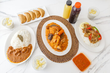 Présentation de plats africains (mets emblématiques comme le Mafé, le Yassa, le Thiep, les Pastels, le Riz au poisson) – spécialités sénégalaises et maliennes vues du dessus (vue à 90°)