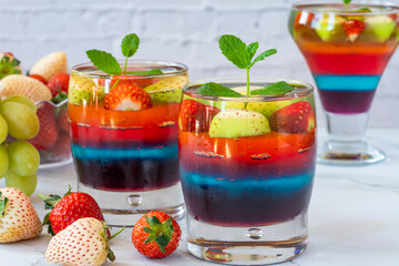 Homemade layered rainbow fruit jelly with fresh fruit