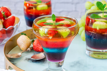 Homemade layered rainbow fruit jelly with fresh fruit