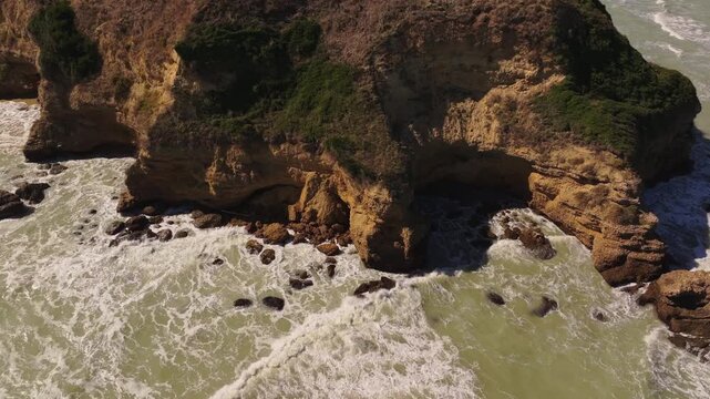 Waves roll softly onto the quiet shore below Punta Aderci.