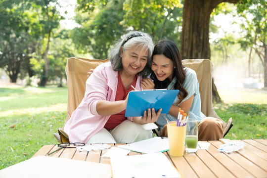 A senior mother and her daughter spend quality time together outdoors, sharing a tender moment filled with love and care. Their strong family bond reflects warmth and togetherness in every embrace